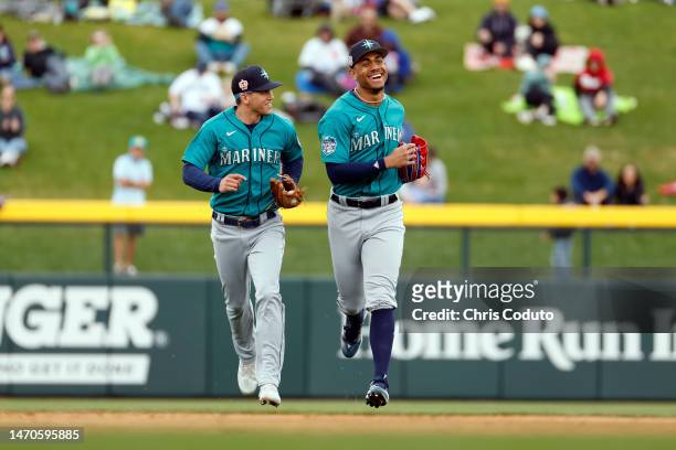 Sam Haggerty and Julio Rodriguez of the Seattle Mariners smile as they leave the field after the end of the third inning of a spring training game...