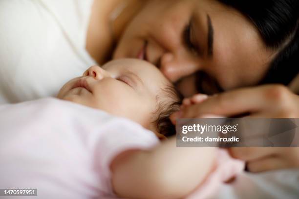 mother and baby sleeping together at home - mom and baby sleeping stock pictures, royalty-free photos & images