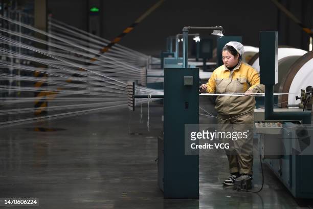 An employee operates a spinning machine at a textile factory on March 1, 2023 in Suqian, Jiangsu Province of China.