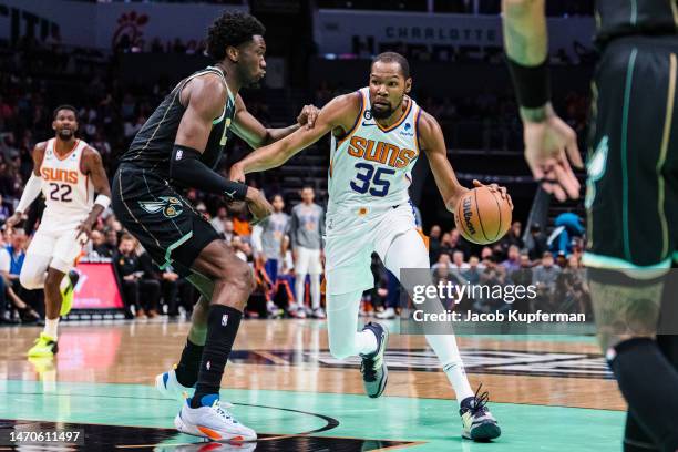 Mark Williams of the Charlotte Hornets guards Kevin Durant of the Phoenix Suns in the first quarter during their game at Spectrum Center on March 01,...