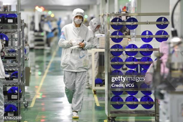 Employees operate machines at a dust-free workshop of a semiconductor factory on March 1, 2023 in Siyang County, Suqian City, Jiangsu Province of...