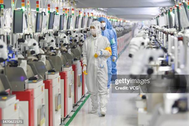 Employees operate machines at a dust-free workshop of a semiconductor factory on March 1, 2023 in Siyang County, Suqian City, Jiangsu Province of...