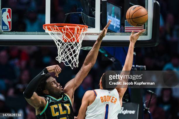 Devin Booker of the Phoenix Suns drives to the basket while guarded by Mark Williams of the Charlotte Hornets in the third quarter during their game...