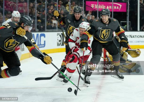 Paul Stastny of the Carolina Hurricanes battles Shea Theodore and Brett Howden of the Vegas Golden Knights during the second period at T-Mobile Arena...