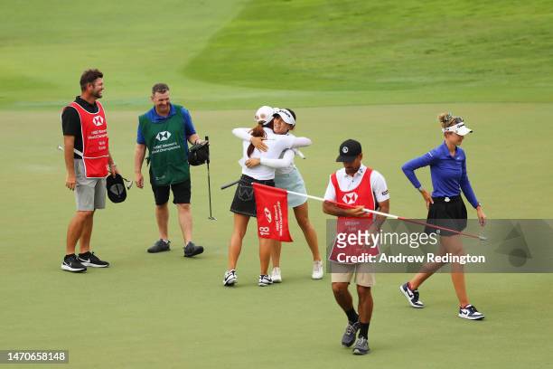 Lydia Ko of New Zealand and Minjee Lee of Australia embrace after finishing their round as Nelly Korda of The United States walks off the eighteenth...