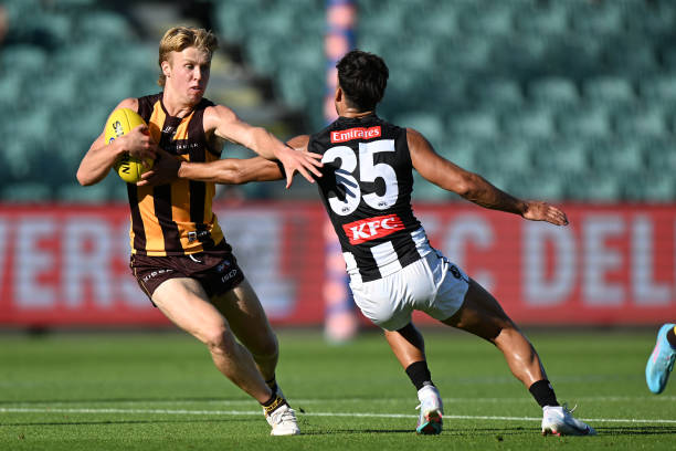 Cam Mackenzie of the Hawks runs the ball during the AFL practice match between the Hawthorn Hawks and the Collingwood Magpies at University of...