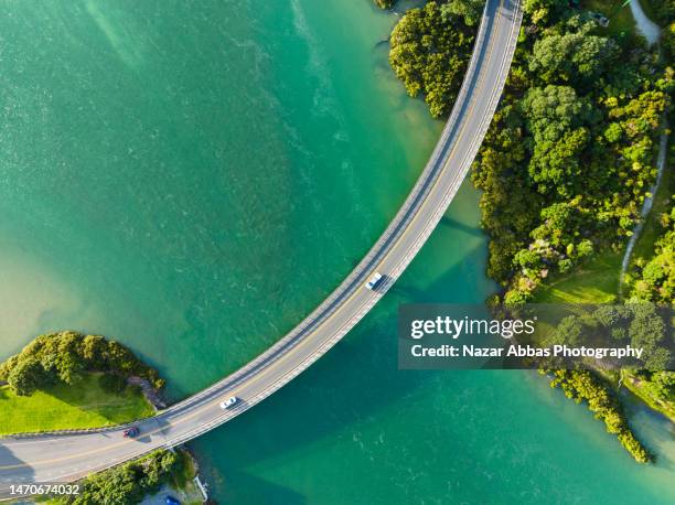 cars passing through bridge that connecting two sides. - blue car stock pictures, royalty-free photos & images