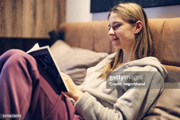 teenage girl enjoying reading a book in bed - teenager reading stock pictures, royalty-free photos & images