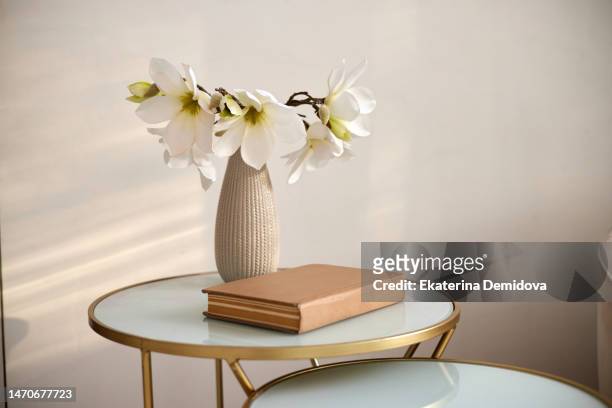 book and vase with flowers on table - bud vase stock pictures, royalty-free photos & images