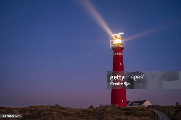 faro en la isla schiermonnikoog en las dunas durante la puesta de sol - atalaya fotografías e imágenes de stock