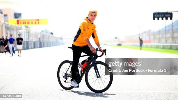 Lando Norris of Great Britain and McLaren rides a bicycle during previews ahead of the F1 Grand Prix of Bahrain at Bahrain International Circuit on...