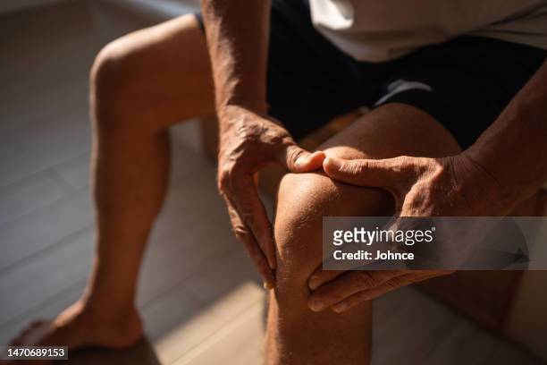 senior man relieving knee pain - tendon stock pictures, royalty-free photos & images