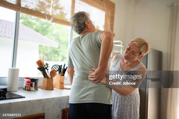 woman supports her husband with pain in his lower back - human head stock pictures, royalty-free photos & images