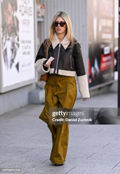 Guest is seen wearing a black and faux fur trim jacket, olive pants and black sunglasses outside the Dries Van Noten show during Paris Fashion Week...