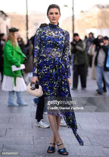Zita d'Hauteville is seen wearing a blue and yellow sheer floral Dries Van Noten dress, shoes and straw cream bag outside the Dries Van Noten show...