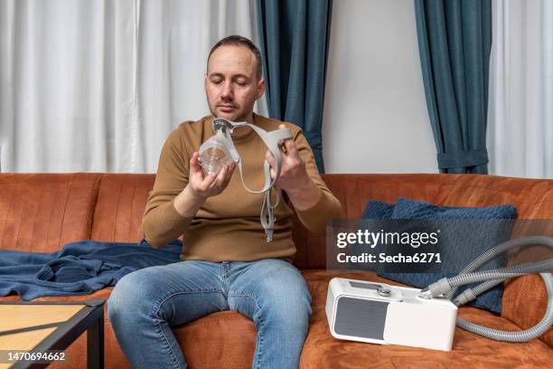 man sleeping with cpap mask because of obstructive sleep apnea - sleep apnea stock pictures, royalty-free photos & images