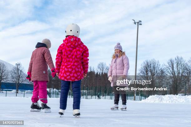 7〜9歳の女性と2人の女の子。白人の家族はリン��クでスケートをしています。 - フィンランド文化 ストックフォトと画像