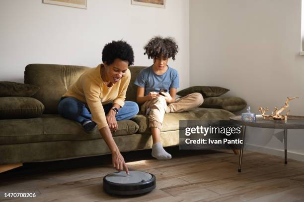 let's turn on this robotic vacuum cleaner! - family robot vacuum stock pictures, royalty-free photos & images
