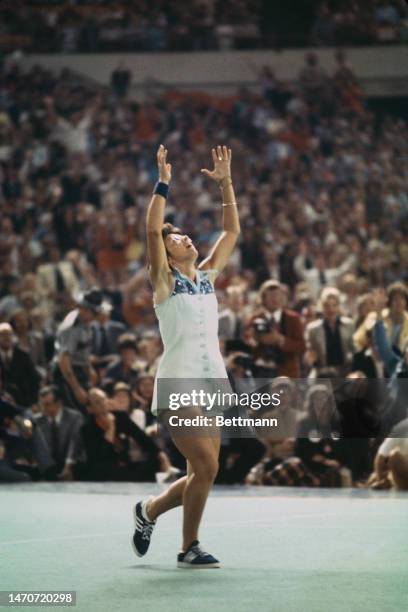 Tennis player Billie Jean King throws her racket in the air after defeating retired pro Bobby Riggs in the 'Battle of the Sexes' match at the Houston...