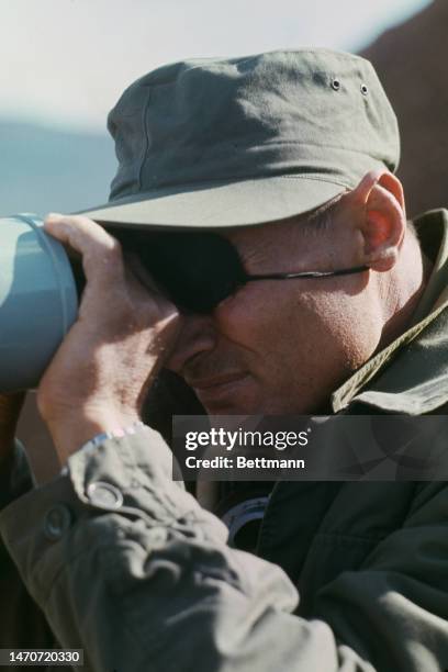 Israeli Defence Minister Moshe Dayan peers through binoculars in the Golan Heights, Israel, on October 18th, 1973.