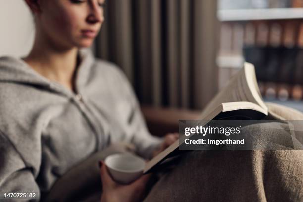 teenage girl enjoying reading a book on couch - lying on back girl on the sofa stock pictures, royalty-free photos & images