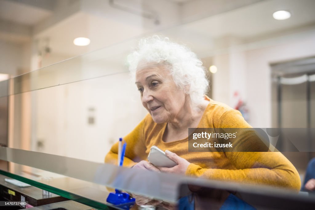 Seniorin an der Rezeption im Krankenhaus