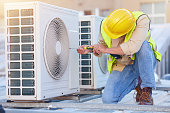 Air conditioning, technician or engineer on roof for maintenance, building or construction of fan hvac repair. Air conditioner, handyman or worker with tools working on a city development project job