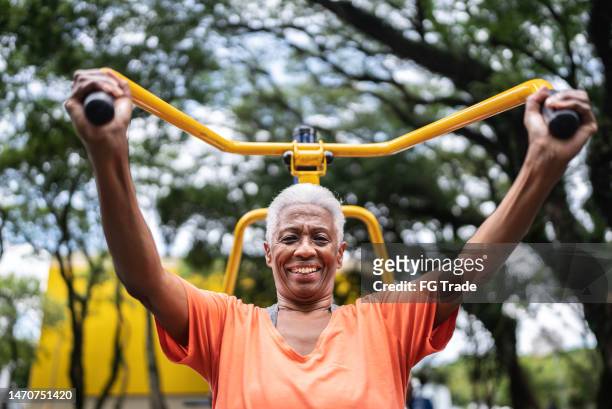 portrait of a senior woman exercising in the park - open workouts imagens e fotografias de stock
