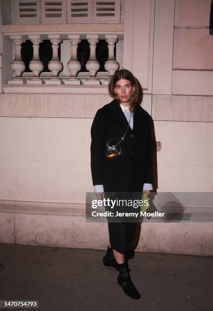 Veronika Heilbrunner seen wearing Acne Studios light blue / white striped button shirt, pearl earrings, Self Portrait shiny leather glitter bow...