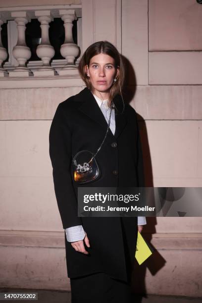 Veronika Heilbrunner seen wearing Acne Studios light blue / white striped button shirt, pearl earrings, Self Portrait shiny leather glitter bow...