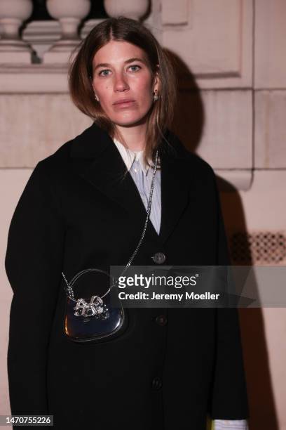 Veronika Heilbrunner seen wearing Acne Studios light blue / white striped button shirt, pearl earrings, Self Portrait shiny leather glitter bow...