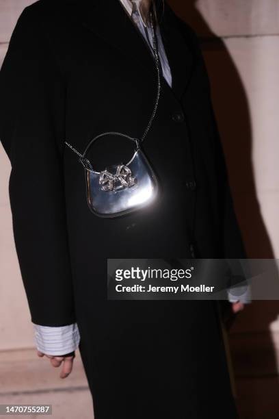 Veronika Heilbrunner seen wearing Acne Studios light blue / white striped button shirt, Self Portrait shiny leather glitter bow crossbody bag, Acne...