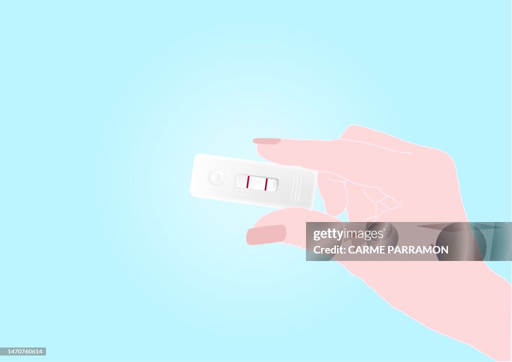 Hand with a positive pregnancy test