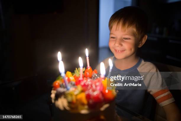 aniversário de 6 anos da criança pequena com um bolo de aniversário e velas - soprando - fotografias e filmes do acervo