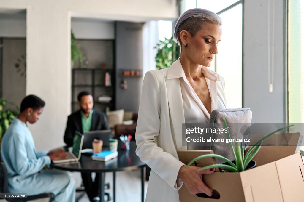 Elegant businesswoman being fired from the office - layoffs and unemployment concept