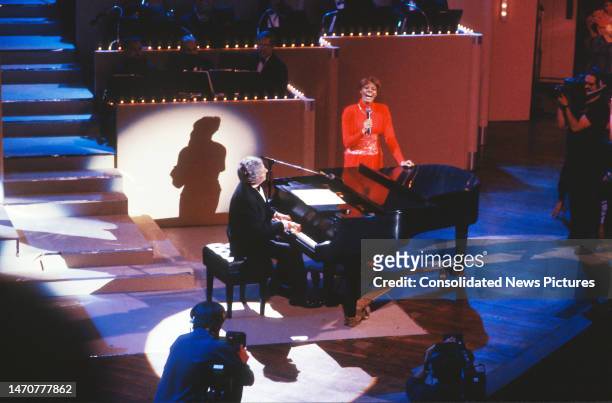 Elevated view of American musician and composer Burt Bacharach , on piano, and singer Dionne Warwick as they perform onstage during 'AIDS Concert...