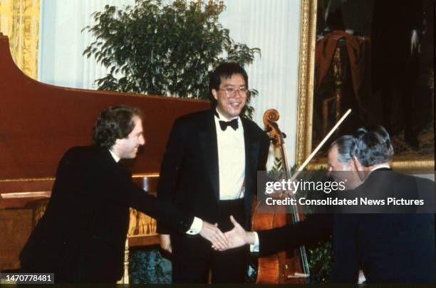 American Classical musician Yo-Yo Ma watches as unidentified others shake hands at the White House, Washington DC, May 13, 1992. Ma had just...