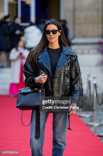 Paula Nata wears jeans, black jacket, Hermès bag at Maison de l’Amérique latine on March 02, 2023 in Paris, France.