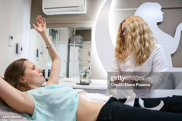 mid adult female doctor puts medicinal bandage to her patient after leeches procedure - leeches stock pictures, royalty-free photos & images