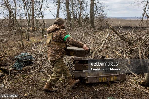 Ukrainian soldier stacks empty artillery ammunition boxes at a firing position near the frontline on on March 02, 2023 in the Donetsk Region of...