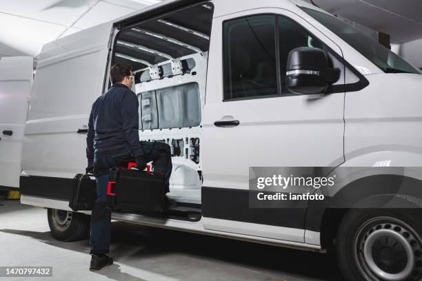 ready for work with a determined attitude, a worker with his tools getting into his white van. - auto interieur stockfoto's en -beelden