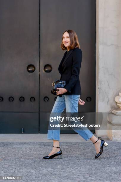 Influencer and style icon Annette Weber, wearing a black blazer by Boss, blue Jeans by Riani, jewelry by Ole Lynggaard, a black varnish bag by Paris...