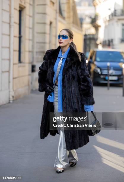 Mina Ceran wears silver trousers, blue blazer, black fake fur coat, Diesel bag and shoes at Maison de l’Amérique latine on March 02, 2023 in Paris,...