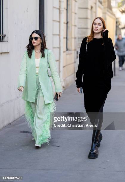 April Hennig mint green blazer, pants & Tiernan Cowling wears black dress at Maison de l’Amérique latine on March 02, 2023 in Paris, France.