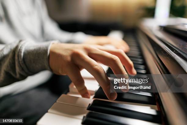 teenage boy practicing piano at home - piano bildbanksfoton och bilder