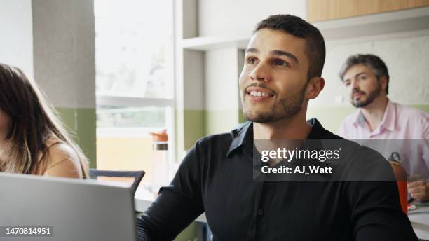 smiling adult student working on a laptop during a classroom lesson - bilingual stock pictures, royalty-free photos & images
