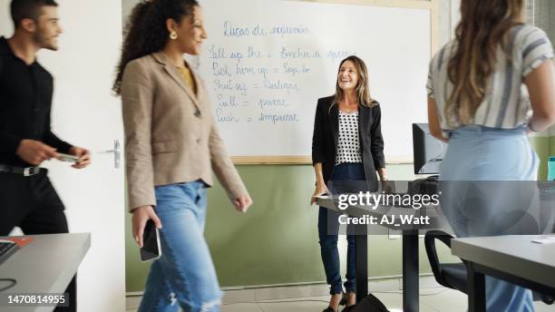 professor de idiomas sorridente cumprimentando alunos adultos em uma classe - languages - fotografias e filmes do acervo