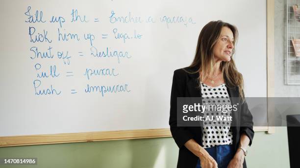 授業中にホワイトボードの前に立つ語学教師 - english language ストックフォトと画像