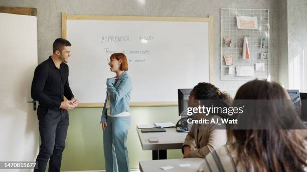 dois alunos adultos conversando durante uma aula de inglês em sala de aula - língua portuguesa - fotografias e filmes do acervo