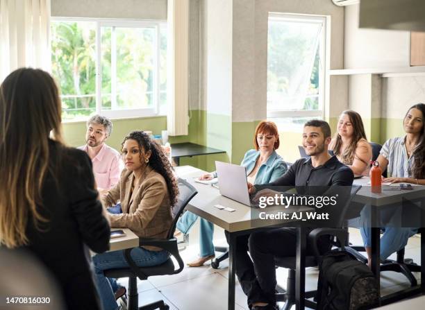 group of adult students paying attention to female lecturer - skill stock pictures, royalty-free photos & images